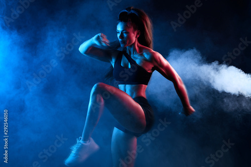 flexible athlete girl concentrated on training exercise, close up side view photo. isolated black background, studio shot, motivation, strength training © the faces