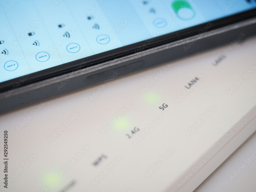 White 5g wifi router and smart phone close up White 5g wifi router and smart phone close up