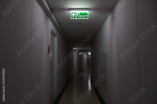 Emergency fire exit sign show the way to escape and low light in walk way