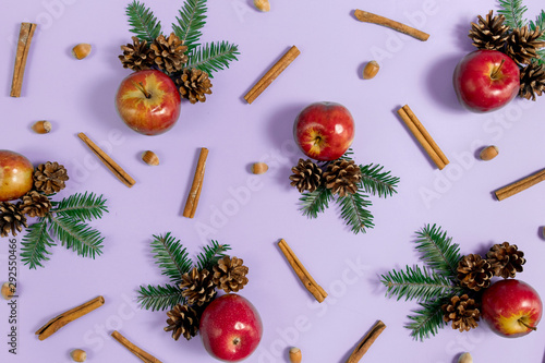 Christmas composition. Tree branches, pine, red apple, acorn and cinnamon on pastel purple background. Christmas, winter, new year concept. Flat lay, top view, copy space