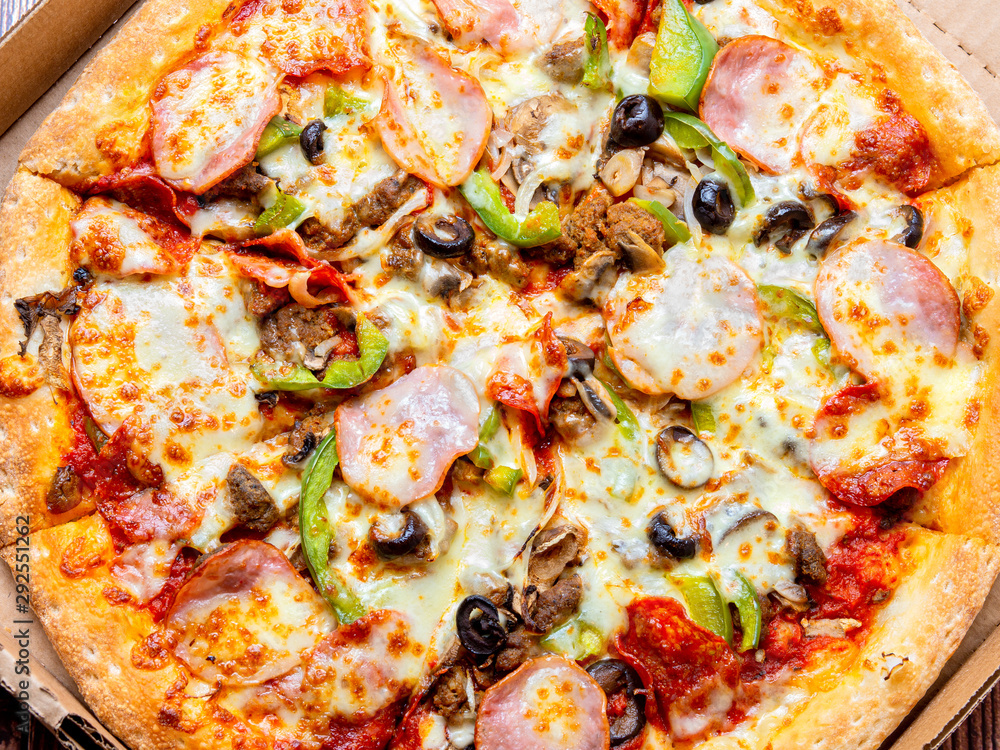 Pizza with meat, cheese and olives in a cardboard box Pizza with meat, cheese and olives in a cardboard box