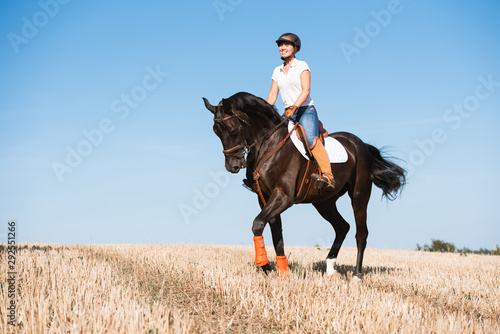 Reiterin trabt mit ihrem Pferd über ein Stoppelfeld und lacht aus ganzem Herzen © Talitha