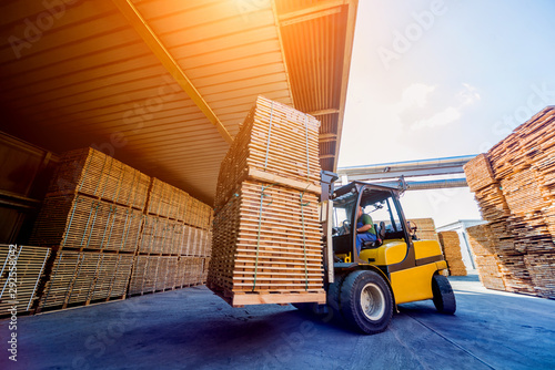 Forklift loader load lumber into a dry kiln. Wood drying in containers. photo