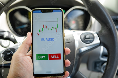 A man hand holding smartphone with mobile Forex trading mock up apps