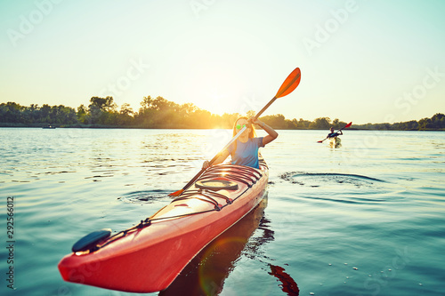 People kayak during sunset in the background. Have fun in your free time.