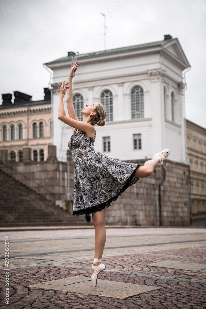Ballerina is posing in the streets, dancing in pointe shoes