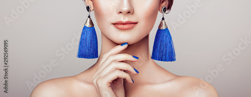 Leinwand Poster Beautiful woman with large earrings tassels jewelry blue color