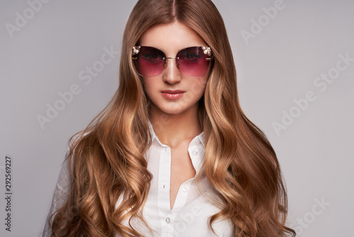 Wallpaper Mural Young woman in elegant sunglasses. Blond hair, isolated studio shot. Fashion lookbook. Brunette girl with long healthy and shiny curly hair Torontodigital.ca