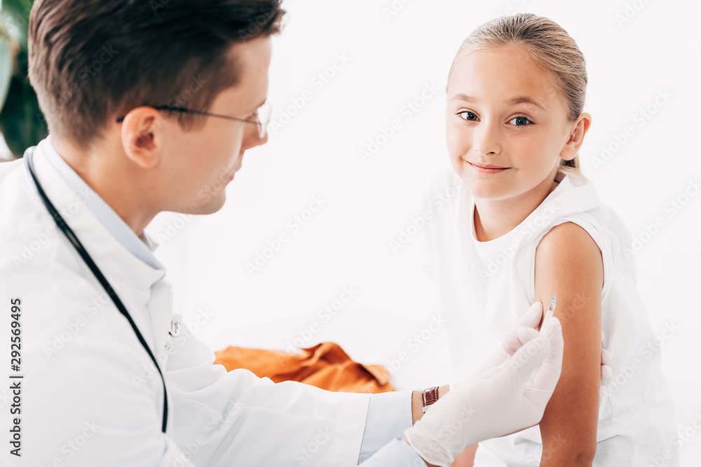 selective focus of pediatrist in latex gloves doing injection to child selective focus of pediatrist in latex gloves doing injection to child
