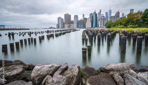 Manhattan financial district on a beautiful summer morning. Long exposure photo of the financial district of Manhattan on a cloudy summer morning  on the old pier - image