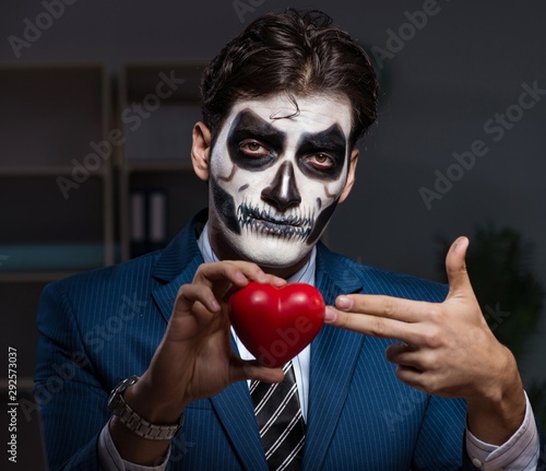The businessman with scary face mask working late in office © Elnur