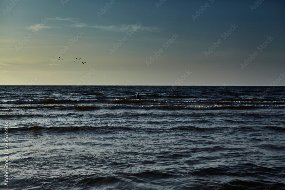 female silhouette against a sunset over the Baltic Sea female silhouette against a sunset over the Baltic Sea