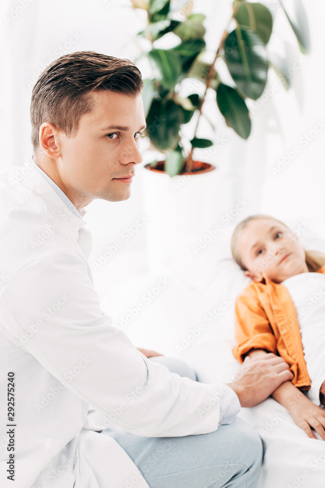 pediatrist in white coat examining child in clinic pediatrist in white coat examining child in clinic