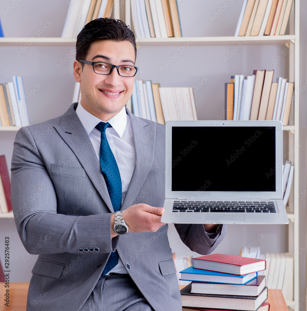 Businessman with a blank screen laptop working in the library Businessman with a blank screen laptop working in the library