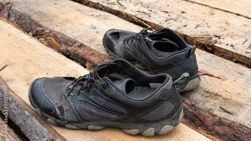 Bilde på lerret torn old shoes on the background of boards
