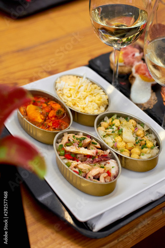A set of traditional portuguese snacks with codfish, mussels, octopus with a glass of vinho verde