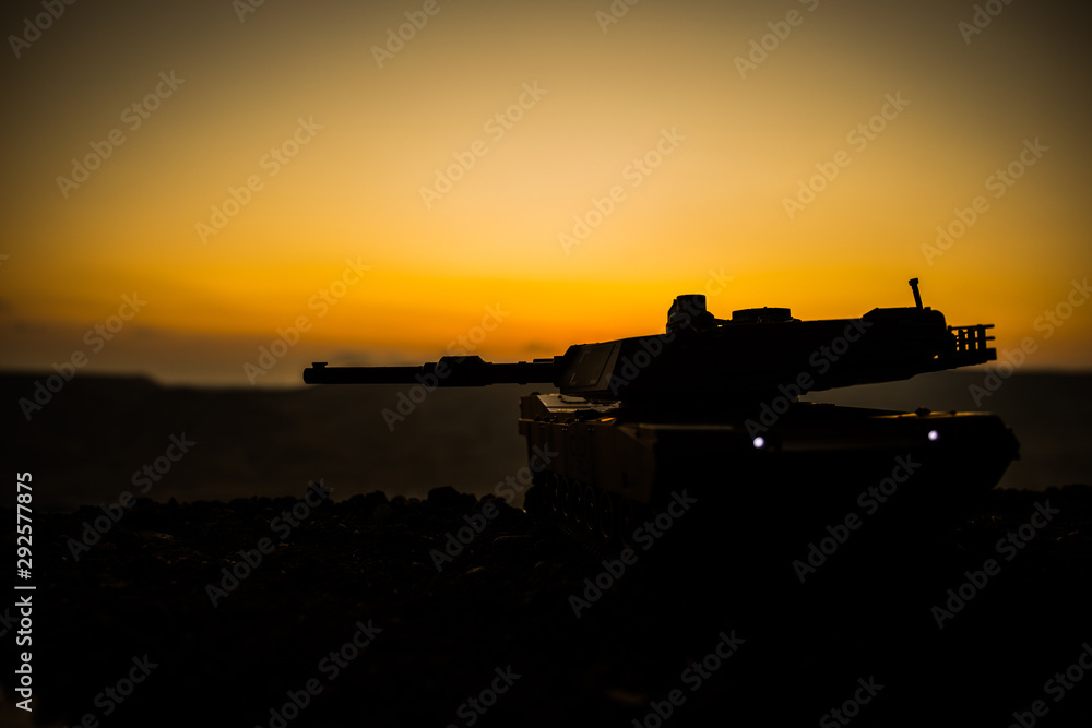 War Concept. Armored vehicle silhouette fighting scene on war fog sky background. American tank at sunset.