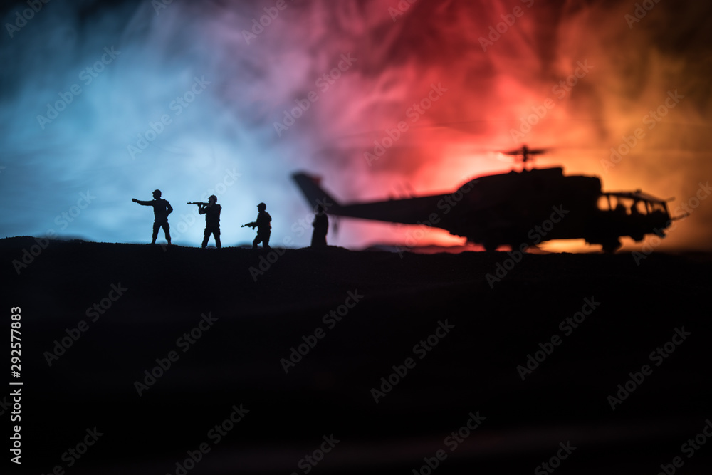 Silhouette of military helicopter ready to fly from conflict zone. Decorated night footage with helicopter starting in desert with foggy toned backlit. Selective focus. Silhouette of military helicopter ready to fly from conflict zone. Decorated night footage with helicopter starting in desert with foggy toned backlit. Selective focus.