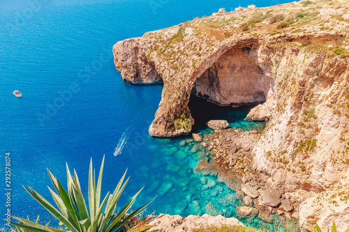 Fototapeta Naklejka Na Ścianę i Meble -  Blue Grotto in Malta. Pleasure boat with tourists runs. Natural arch window in rock