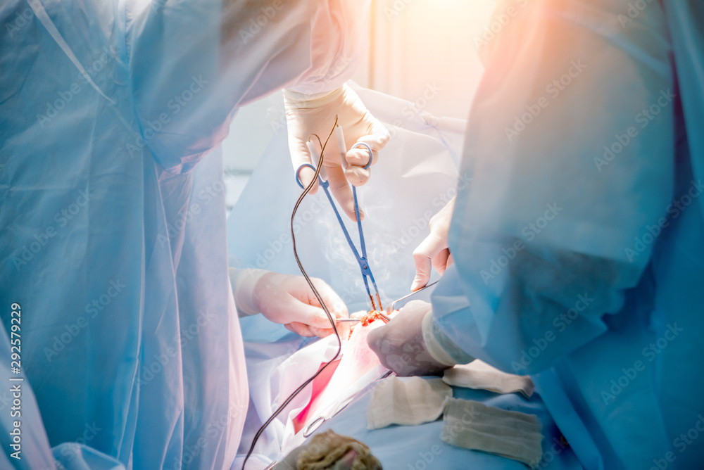 Surgeon and assistants in operating room with surgery equipment. Surgeon and assistants in operating room with surgery equipment.