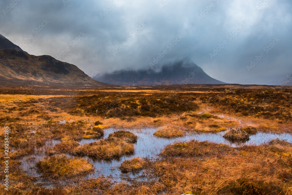 Buachaille Etive Mor shrouded in clouds with marshy water and grass in the foreground. Glencoe, Scotland Buachaille Etive Mor shrouded in clouds with marshy water and grass in the foreground. Glencoe, Scotland
