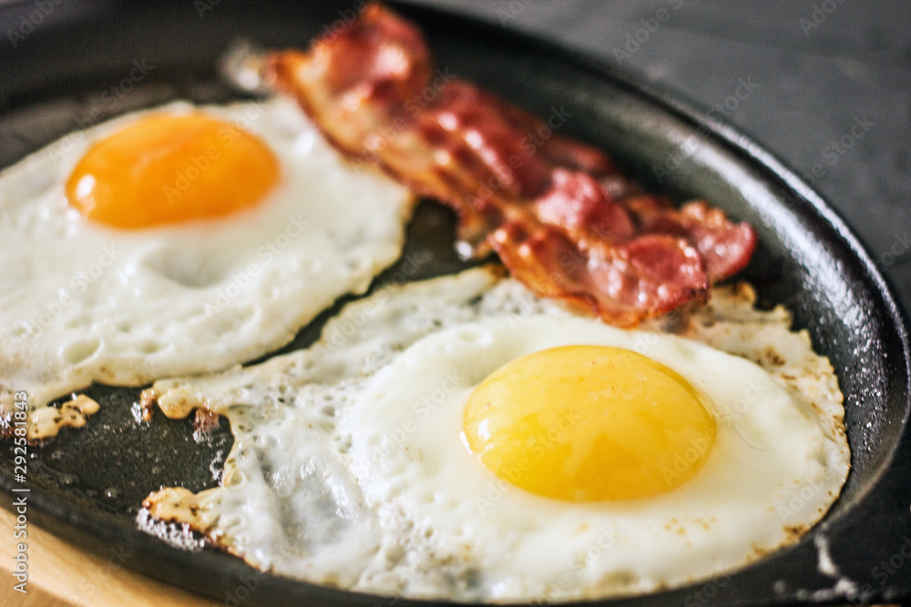 Fried eggs with bacon in a pan. Classic bacon and eggs. Keto Diet LCHF Keto breakfast. Low carb diet concept. high fat diet. Fried eggs and crispy bacon closeup Fried eggs with bacon in a pan. Classic bacon and eggs. Keto Diet LCHF Keto breakfast. Low carb diet concept. high fat diet. Fried eggs and crispy bacon closeup