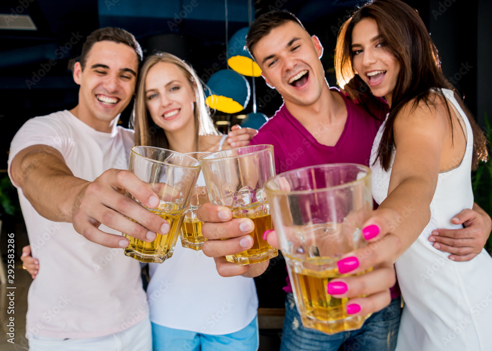 Cheerful friends in the pub. Drinking beer, talking, having fun. Cheerful friends in the pub. Drinking beer, talking, having fun.