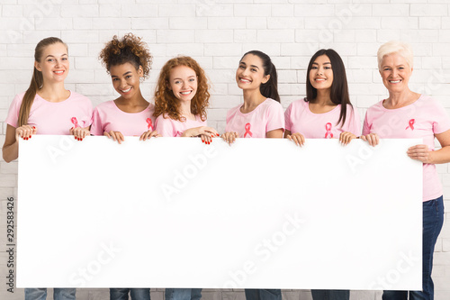 Women In Pink T-Shirts Holding White Board Over Brick Wall