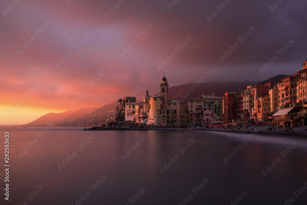 That's a long exposure taken in December of 2018 in Camogli, near Genoa, Italy. The main subject is the famous church of Camogli, which is surrounded by a purple cloudy sky and a beautiful purple and 