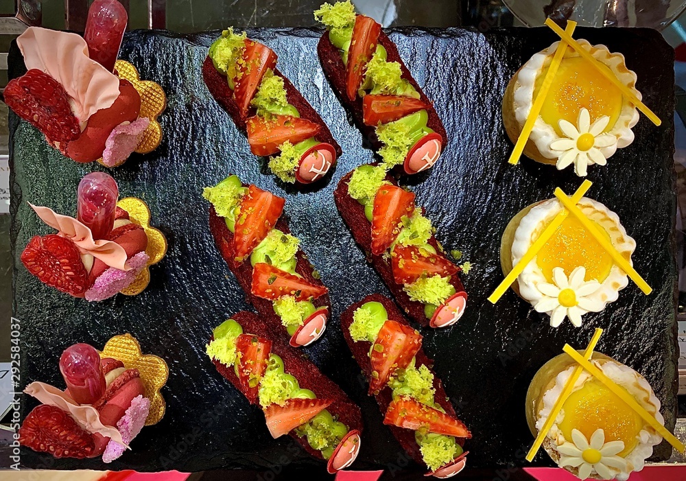 Fototapeta premium sushis and desserts placed on a black iron board