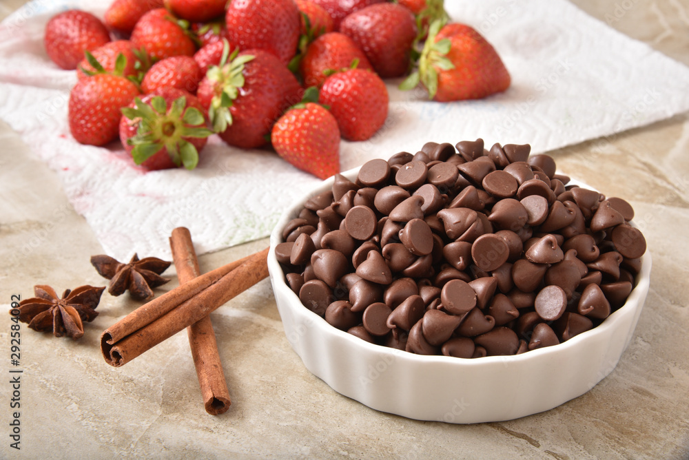 Fototapeta premium Bowl of milk chocolate chips with strawberries