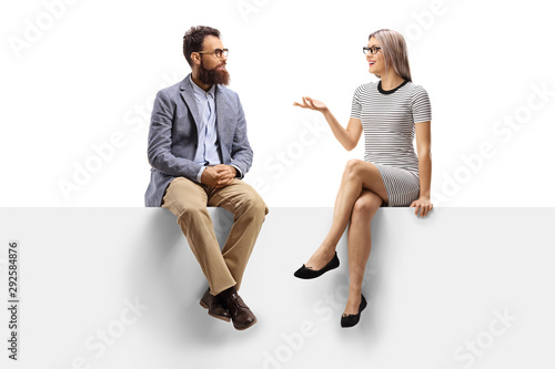 Fotografie, Obraz Young woman having a conversation with a bearded man while sitting on a panel