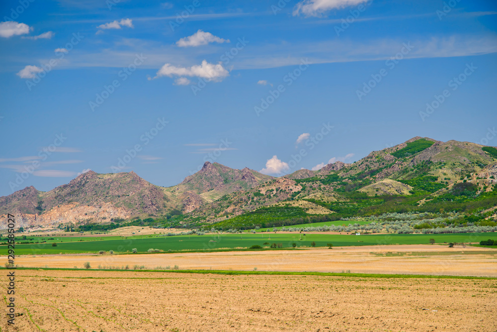 Flat fields and arid hill in summer