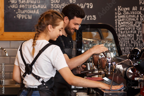 Slika na platnu Two young smiling barista at work
