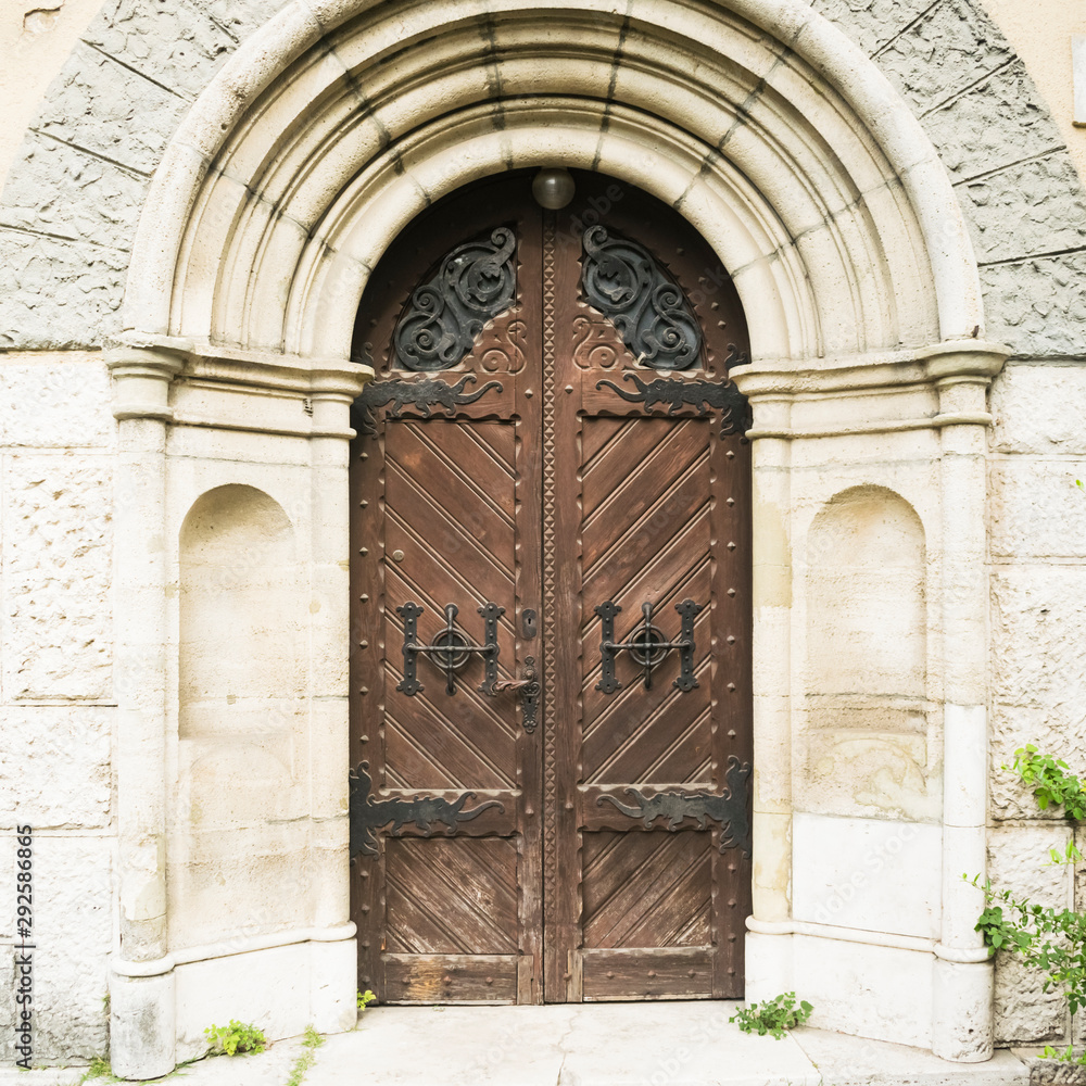 Vintage background featuring detail of exterior brown door of castle in City Park of Budapest, Hungary.