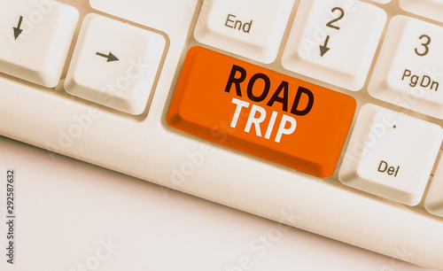 Writing note showing Road Trip. Business concept for Roaming around places with no definite or exact target location White pc keyboard with note paper above the white background photo