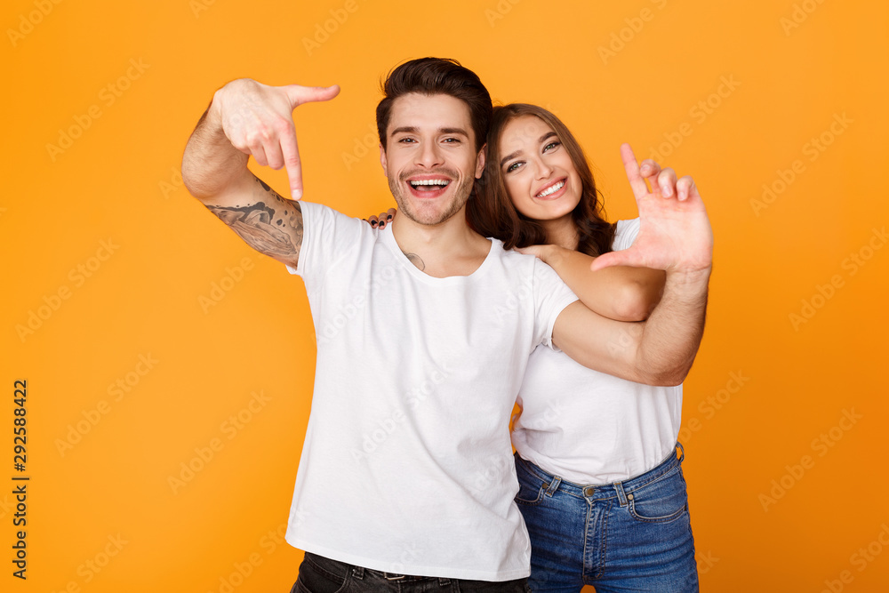 Excited couple showing frame sign with hands Excited couple showing frame sign with hands