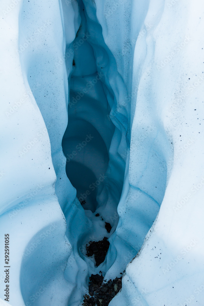 Deep dark canyon cut into the ice of a glacier in Alaska. Deep dark canyon cut into the ice of a glacier in Alaska.
