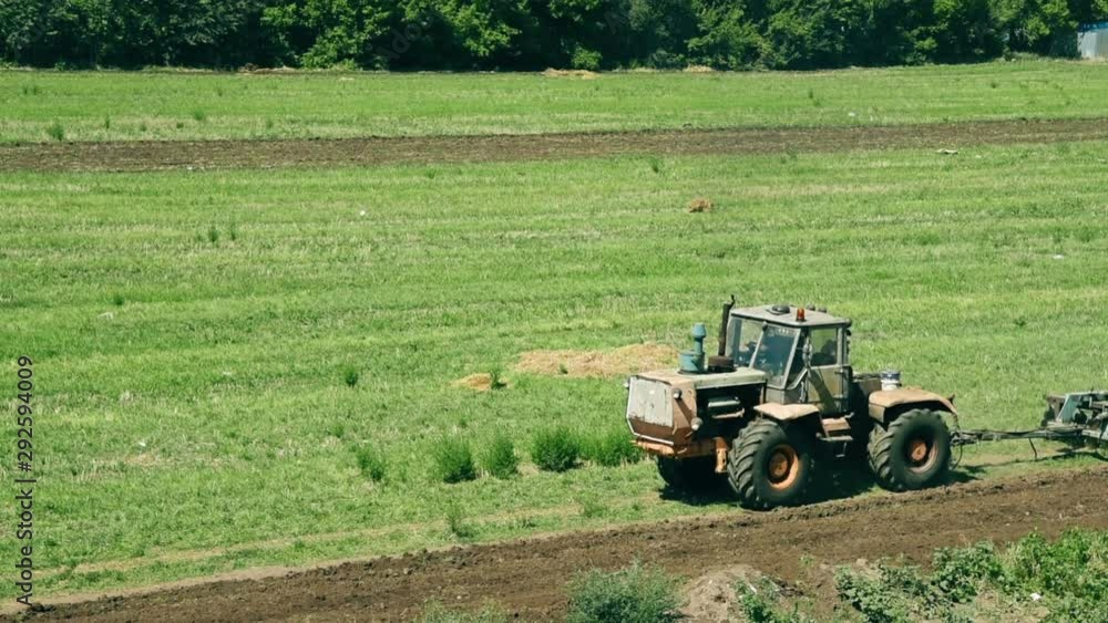 Tractor Preparing Land For Sowing During Sunny Autumn Day. Farming Concept Tractor Preparing Land For Sowing During Sunny Autumn Day. Farming Concept