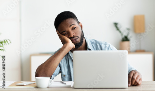 Bored employee sitting in office can not concentrate on work photo