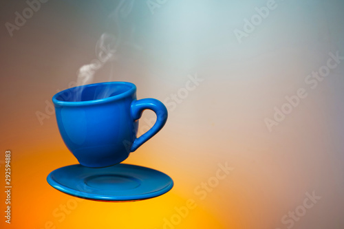 Floating blue cup of espresso. Mock up of soaring in the air cup of hot coffee