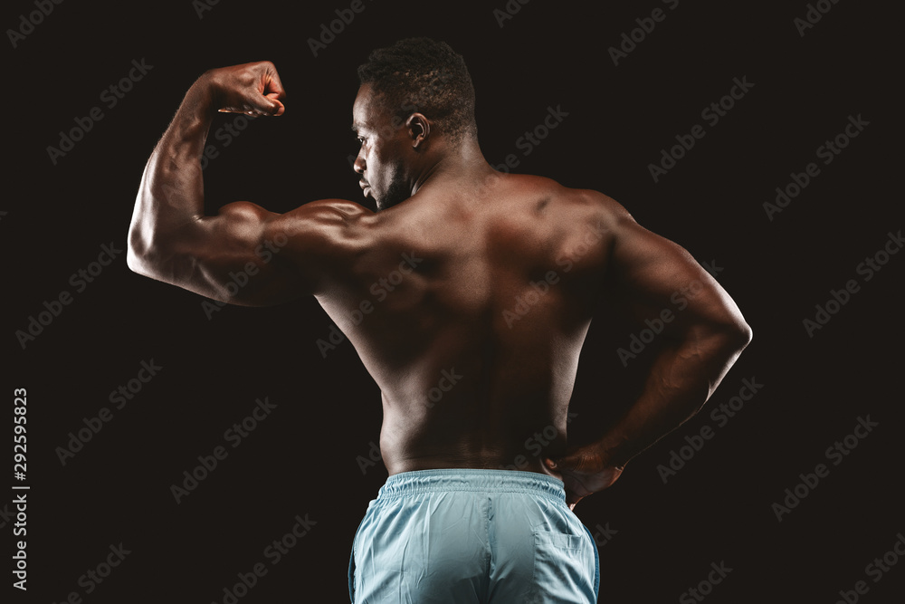 Strong afro bodybuilder demonstrating his muscular biceps