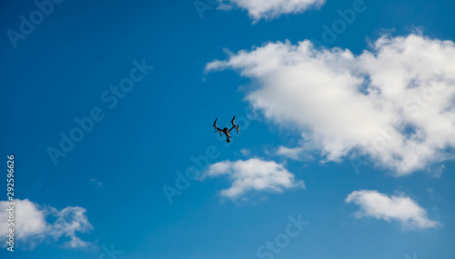 the quadcopter hovered above the clouds against the blue sky