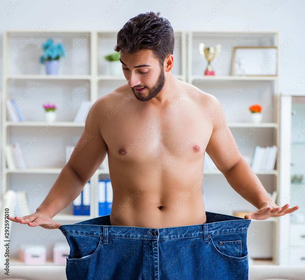 Man in oversized pants in weight loss concept Man in oversized pants in weight loss concept