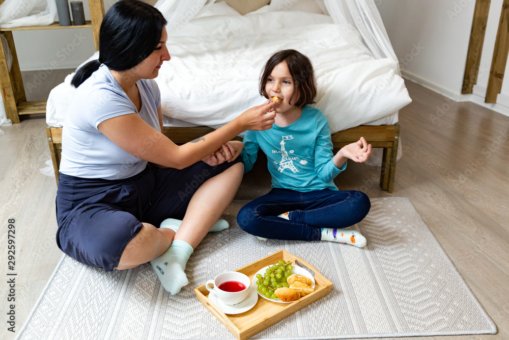 Early morning breakfast of little girl with her mom in the bedroom