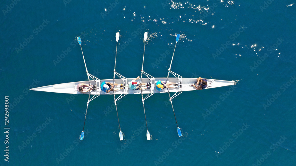 Naklejka premium Aerial top down photo of sport canoe operated by team of young men in open ocean deep blue sea
