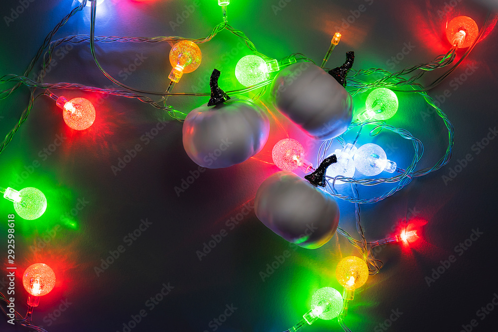 Concept for happy halloween with white pumpkins and bright vivid christmas light on night background. Copy space, advertising template on trend, conceptual banner for halloween. Mystery. Concept for happy halloween with white pumpkins and bright vivid christmas light on night background. Copy space, advertising template on trend, conceptual banner for halloween. Mystery.