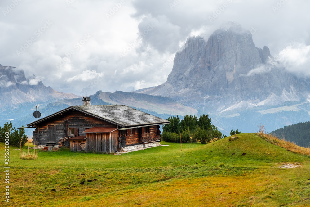 Mountain meadow and houses in Gardena valley and Seceda peak , background Alpe di Siusi or Seiser Alm in the with Province of Bolzano, South Tyrol in Dolomites