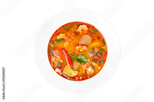 Closeup top view image of a plate of traditional thai soup - tom yum kung isolated at white background.