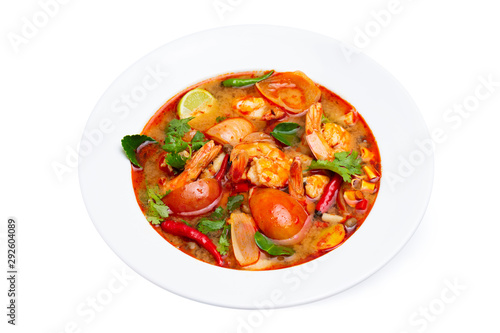Closeup plate of traditional thai soup - tom yum kung with shrimps and tomatoes isolated at white background.